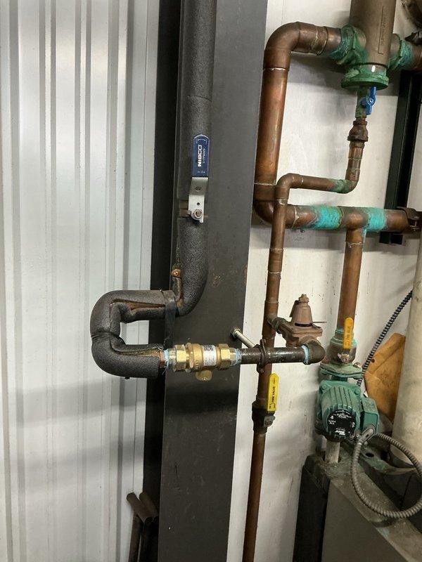 Responded to a water leak in the commercial mechanical room and identified a leaking backflow preventer on the hydronic boiler makeup water piping. Isolated the line, removed the failed unit, and installed a new Watts 9D backflow preventer. Restored water supply and verified the assembly operates properly with no leaks.