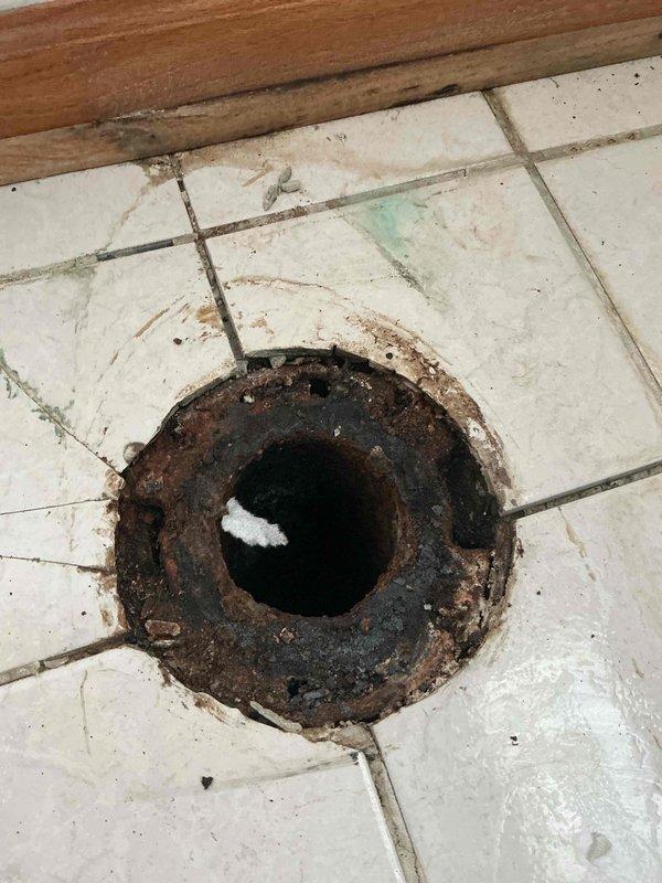 Installed the customer-supplied toilet and diagnosed the second toilet's flushing issue, which was traced to a heavily corroded cast-iron closet flange with cracked surrounding floor tile; the flange requires rebuilding with a mechanical repair flange. The basement sump pit was also inspected, and the existing pump was found to need replacement with a new grinder pump. Both repairs have been forwarded to on-call for scheduling and completion.