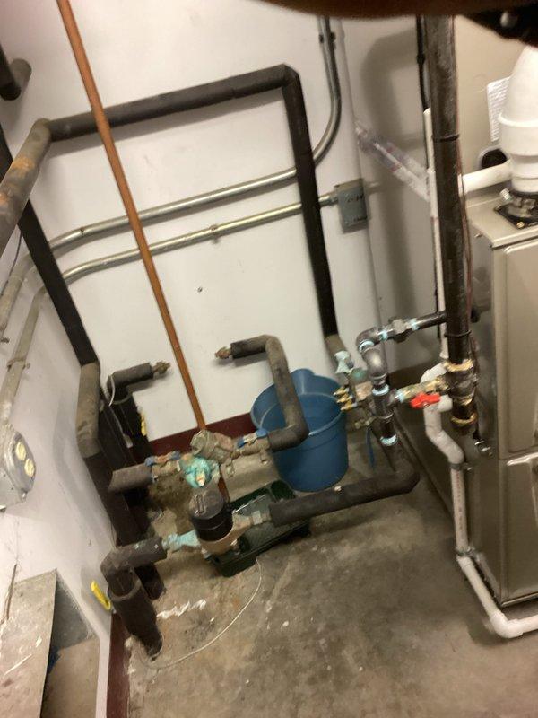 # HVAC Install - Complete System - Commercial

Completed full commercial HVAC system installation including multiple outdoor condensing units and associated indoor mechanical components. Installed three exterior condenser units against building perimeter, consisting of one York unit with protective cage enclosure and two additional condensing units mounted on equipment pads with proper gravel base for drainage and stability. All exterior units positioned to ensure adequate airflow clearance and service access.

Interior installation included complete mechanical room setup with new water heater tank, copper and PVC supply lines, gas piping distribution system with shut-off valves, and pressure relief components. Installed furnace unit with proper venting and integrated all plumbing connections including hot and cold water distribution manifolds. All piping secured with appropriate hangers and supports per code requirements. System includes multiple zone control valves and isolation poin