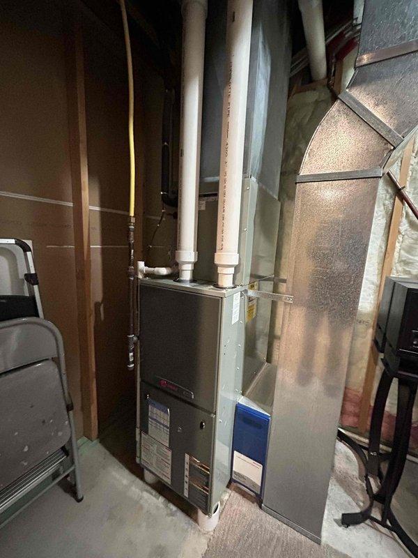 Responded to no heat call on 20-year-old Trane gas furnace with cracked heat exchanger. Performed comprehensive assessment of existing basement installation, documented equipment measurements and configuration including PVC vent piping and ductwork connections. Provided detailed replacement estimate for new furnace system while noting customer's intention to continue using existing heat pump for cooling until failure.