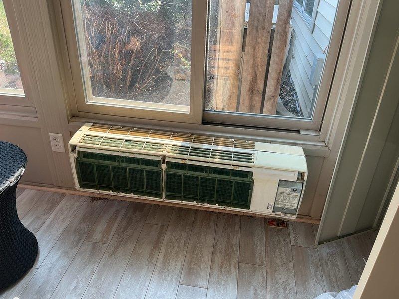 Conducted on-site evaluation for mini-split system installation in detached multi-level pool house structure. Customer requested 12,000 BTU capacity unit for climate control. Assessed existing four-season room area containing older wall-mounted PTAC or mini-split unit of questionable operational status requiring further discussion regarding potential replacement or integration with new system. Documented interior space dimensions, wall configurations, and existing HVAC equipment through photographic documentation to determine optimal equipment sizing and installation approach.