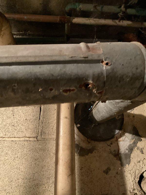 Conducted follow-up assessment of basement utility systems per previous technician's recommendations. Inspected tanked water heater showing significant age-related deterioration, including extensive rust formation on tank exterior and corroded copper supply lines. Evaluated sump pump operation in response to reported noise issues. Documented moisture damage on basement floor and foundation walls indicating potential drainage concerns. Photographed water heater condition and surrounding plumbing infrastructure to support replacement recommendations for aging equipment.