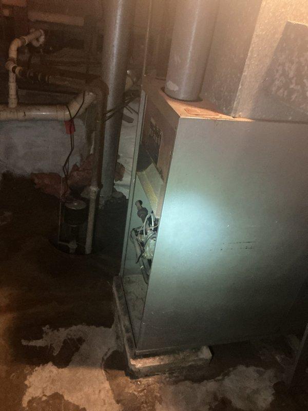 Conducted comprehensive assessment of existing HVAC system in basement utility area for equipment replacement estimate. Evaluated aging turquoise-colored gas furnace unit showing significant wear, surface corrosion, and deteriorated paint finish. Inspected internal components through accessible service panel and assessed condition of vertical supply ductwork extending from unit. Examined associated copper plumbing lines, valves, and fittings displaying corrosion and age-related degradation. Evaluated thermostat location and current wall-mounted control system with brass-finished round faceplate. Documented equipment specifications, existing installation configuration, and system layout. Provided replacement options for gas furnace and air conditioning system. Discussed available promotional offers and financing options with homeowner. Captured photographic documentation of existing equipment condition and installation area for estimate preparation.