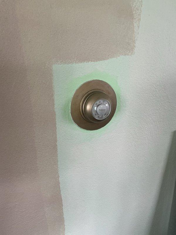 Conducted comprehensive assessment of existing HVAC system in basement utility area for equipment replacement estimate. Evaluated aging turquoise-colored gas furnace unit showing significant wear, surface corrosion, and deteriorated paint finish. Inspected internal components through accessible service panel and assessed condition of vertical supply ductwork extending from unit. Examined associated copper plumbing lines, valves, and fittings displaying corrosion and age-related degradation. Evaluated thermostat location and current wall-mounted control system with brass-finished round faceplate. Documented equipment specifications, existing installation configuration, and system layout. Provided replacement options for gas furnace and air conditioning system. Discussed available promotional offers and financing options with homeowner. Captured photographic documentation of existing equipment condition and installation area for estimate preparation.