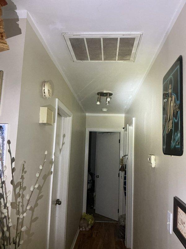 Completed on-site evaluation for complete HVAC system installation in residential property currently utilizing electric baseboard heat with no existing forced air system. Assessed requirements for new gas furnace, air conditioning unit, and complete ductwork installation throughout home. Documented existing conditions including attic space accessibility for equipment placement and ductwork routing, evaluated hallway ceiling area for potential return air grille locations, and determined scope of work needed to transition from electric baseboard to central forced air heating and cooling system.