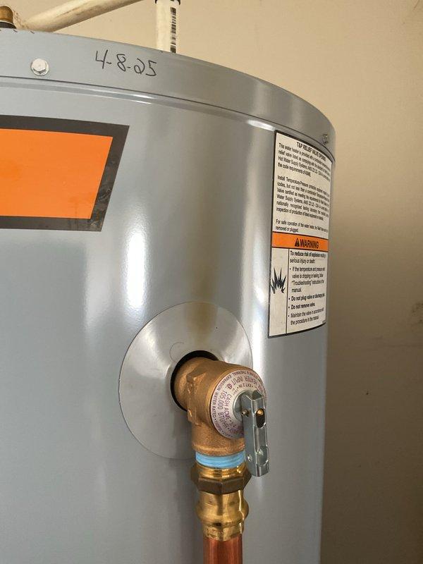 Responded to service call for tanked water heater with reported brown discoloration near temperature-pressure relief valve and inconsistent water temperature issues. Upon inspection, evaluated the TP valve assembly and surrounding connections for signs of mineral deposits, corrosion, or discharge. Assessed water heater operation and temperature settings to address concerns regarding excessively hot water conditions versus inadequate hot water delivery during use. Documented equipment condition through photographic records showing TP valve configuration, brass relief valve assembly with copper discharge piping, maintenance tracking labels, and overall unit status. Verified proper valve function and examined potential causes of temperature inconsistencies affecting household hot water supply.