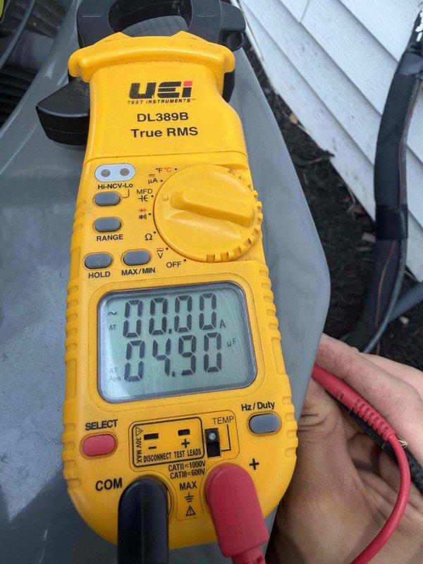 Completed prepaid cooling season maintenance check on residential air conditioning system. Performed electrical diagnostics using digital multimeter to verify proper voltage and amperage readings across capacitor and associated wiring connections. Inspected capacitor with multiple wire terminations, confirmed all spade connectors secure with proper heat-shrink insulation, and verified system operational parameters within manufacturer specifications.