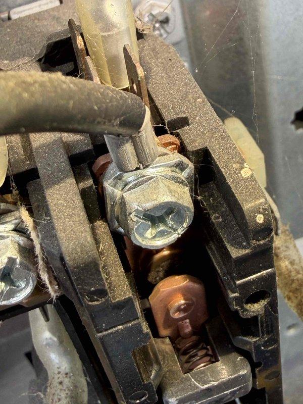 Completed first-year cooling tune-up on residential outdoor condensing unit. Performed comprehensive inspection of electrical connections, noting corrosion on terminal block screws and accumulated debris on components. Unit operational with adequate airflow through vertical louvers; system running within normal parameters on concrete pad with proper clearances maintained.