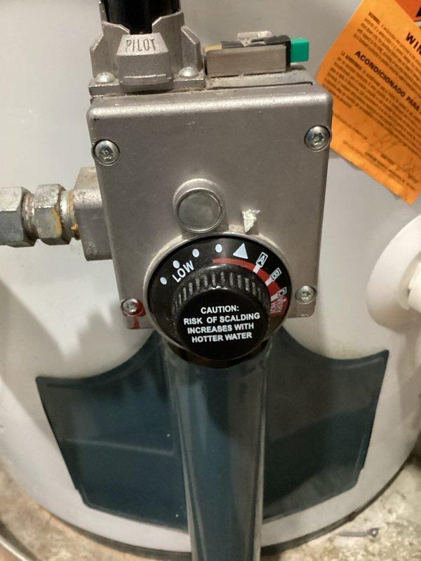Responded to no hot water complaint following recent AC installation in tight workspace. Upon arrival, inspected gas water heater and verified gas control valve had been inadvertently switched to off position, likely bumped during AC installation work. Restored gas supply to water heater, relit pilot light, and verified proper operation and hot water delivery to fixtures throughout home.