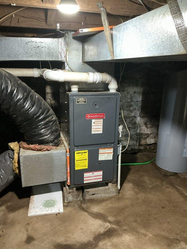 Conducted on-site assessment of existing Goodman furnace and air conditioning system for replacement quote due to equipment age. Inspected basement mechanical room installation, documenting current furnace configuration including PVC venting, ductwork connections, and electrical service. Evaluated existing system specifications from manufacturer labels and assessed accessibility for replacement equipment. Photographed furnace unit, surrounding mechanical components, ductwork layout, and basement access points to determine installation requirements and equipment sizing for replacement proposal.