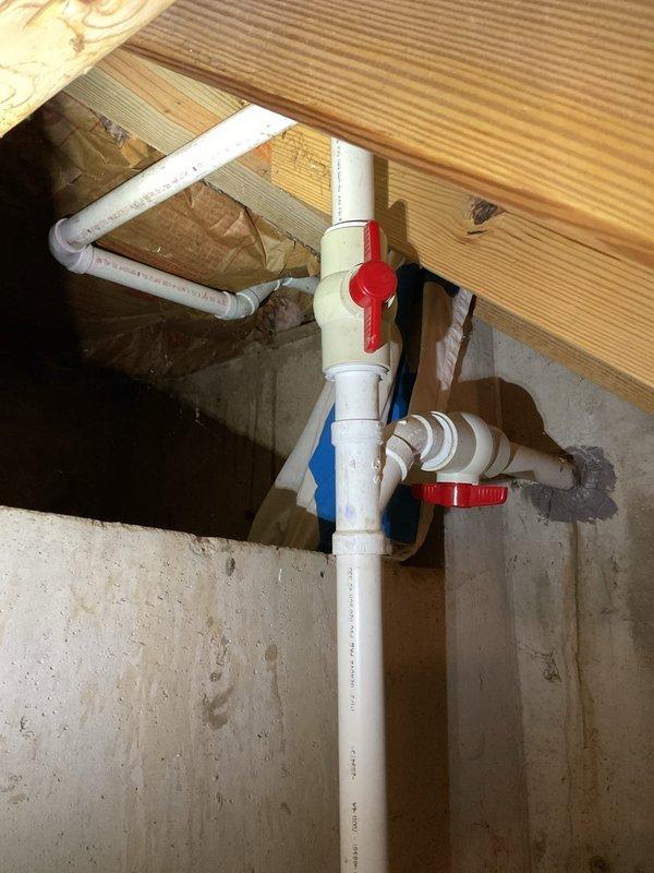 Performed inspection and evaluation of existing sump pump system per customer request to assess current discharge configuration and explore alternative routing options. System was found to be operational but functioning below optimal efficiency. Examined white PVC discharge piping with dual ball valves, vertical run through floor joists, and connection points in basement area. Assessed pump unit positioning on concrete floor, electrical connections, and current discharge path routing along foundation walls. Identified opportunities for system modification to improve discharge flow and overall performance. Documented existing installation with photographs showing piping layout, valve configuration, and pump placement for reference in developing recommended modifications to enhance system effectiveness.