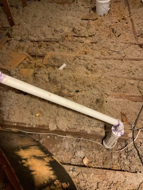 Responded to repair damaged plumbing exhaust vent lines in attic space that were broken during recent roof installation. Accessed attic area and inspected white PVC vent piping with purple primer markings running vertically through roof structure. Assessed damage to vent stack and connections where roofing contractor had compromised the existing plumbing ventilation system. Repaired and reinstalled proper venting configuration to restore functionality of plumbing exhaust lines, ensuring all connections were secure and properly sealed. Verified vent pipes extended correctly through roof penetrations and all joints were watertight to prevent future leaks or system failures.