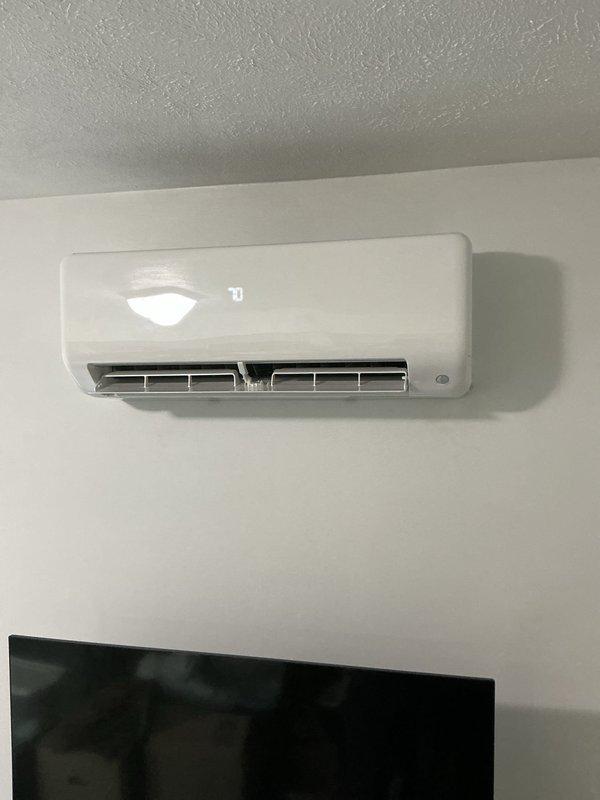 Completed installation of Carrier Performance Series inverter-driven heat pump mini-split system, including model 37MARAQ12AA3 outdoor condenser unit and D5MAHAQ12XA3 variable speed indoor air handler. Mounted indoor evaporator unit on interior wall, positioned outdoor condenser on new 2" PVC pad on gravel base against exterior wall, and ran new 10-foot line set between units with line hide section for aesthetic concealment. Licensed electrician installed high voltage power supply to outdoor unit with new disconnect box and whip. Installed black insulated refrigerant lines secured to exterior siding with clips, connected all refrigerant piping, evacuated system, and charged to manufacturer specifications. Ran white PVC condensate drain line along exterior wall for proper drainage. Performed system startup, verified proper operation of all components including inverter technology and heat pump functionality, and confirmed adequate airflow and temperature differential. Registered manufac