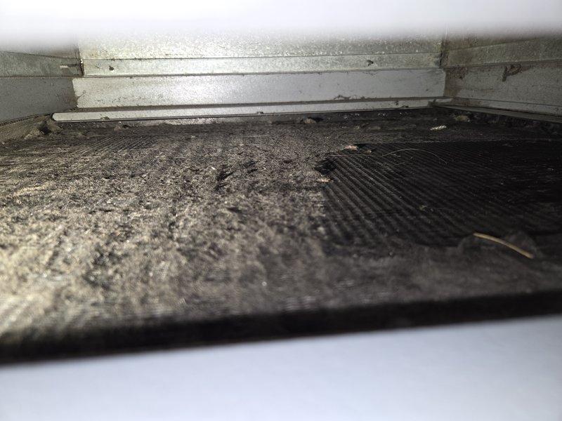 Responded to no cooling complaint on geothermal system with indoor temperature at 77°F and not dropping. Upon inspection, discovered severely clogged air filter with excessive dust and debris accumulation, restricting airflow through the air handler. Replaced dirty filter and verified system operation. Unit now cooling properly with adequate airflow restored through ductwork and Space-Gard air cleaner assembly.