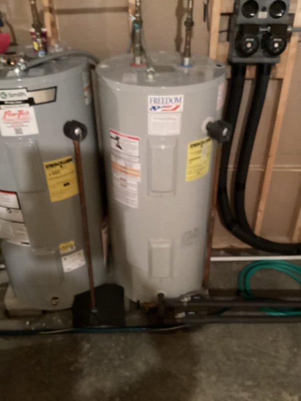 Provided estimate for replacement of leaking water heater serving as storage tank for geothermal hot water assist system. Unit exhibiting leak at base requiring full replacement. Assessed existing dual water heater configuration with interconnected copper piping system and documented current installation with photographs for estimate preparation.
