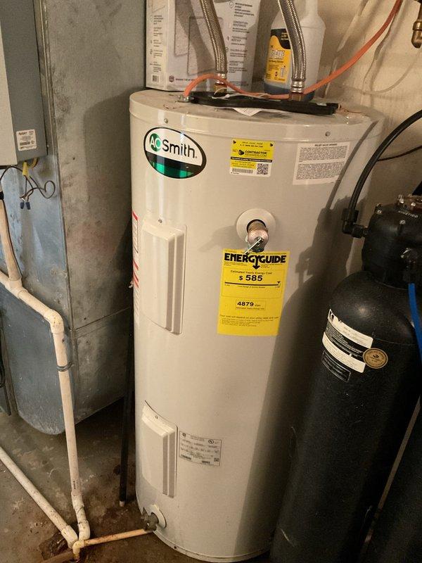 Provided estimate for installation of customer-supplied REMC electric tank water heater in basement location. Assessed existing A.O. Smith electric water heater currently elevated on brick platform with integrated Kenetico water softener system connection. Evaluated installation requirements including electrical connections, water supply lines with flexible braided hoses, pressure tank configuration, and proper integration with existing water softener plumbing to prepare comprehensive installation quote for customer-provided unit.