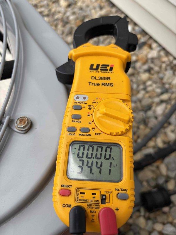 Performed routine maintenance inspection on residential cooling system. Used clamp meter to verify electrical readings, measuring current draw at 00.00A and capacitance at 344µF on outdoor unit components. Additionally measured resistance at 24.00Ω and confirmed system voltage at 25.90V to ensure proper operation. All electrical parameters were within manufacturer specifications, and unit is operating normally for the cooling season.
