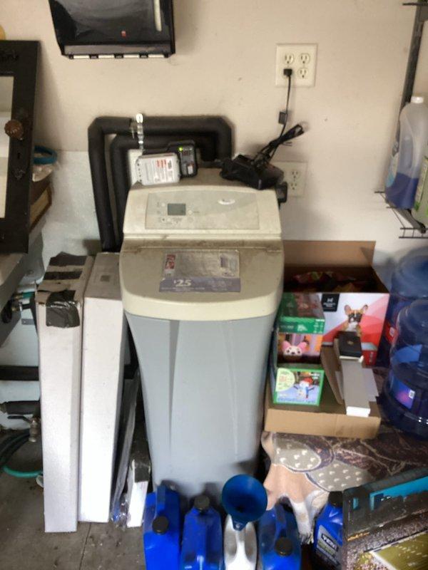 Provided estimate for replacement of existing water softener unit, which is over 15 years old and no longer functioning effectively. Assessed current system located in garage, including existing water filtration components with translucent filter housing and connecting plumbing infrastructure. Documented equipment condition and photographed installation area to prepare comprehensive replacement proposal for new water treatment system.