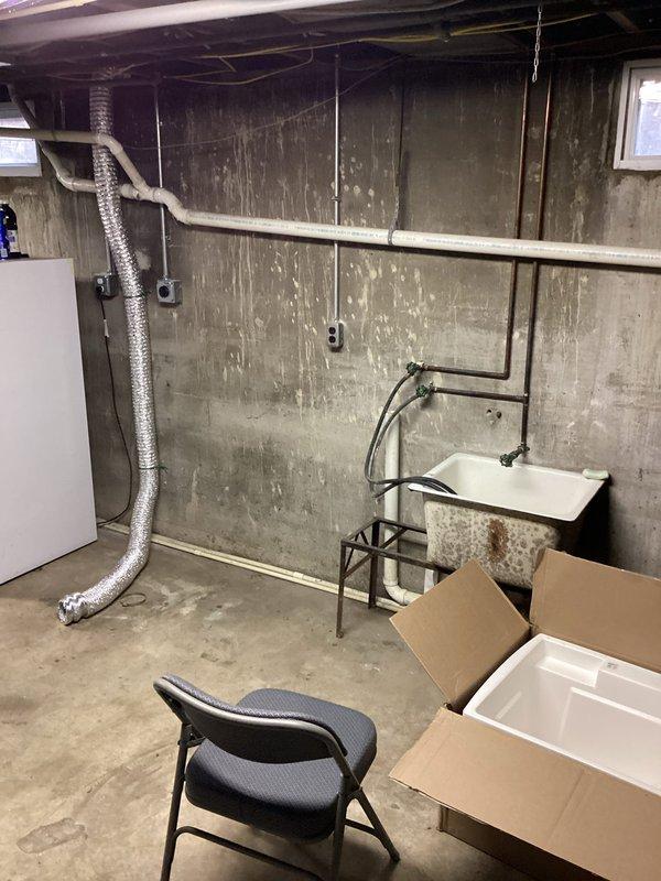 Installed a sewage ejector pump system in the basement to accommodate the relocation of washer and dryer from the main floor. The pump was positioned adjacent to the existing utility sink to handle gray water discharge from the relocated laundry appliances. New PVC drain lines were routed and connected to facilitate proper drainage through the pump system, ensuring compliance with code requirements for below-grade plumbing fixtures.