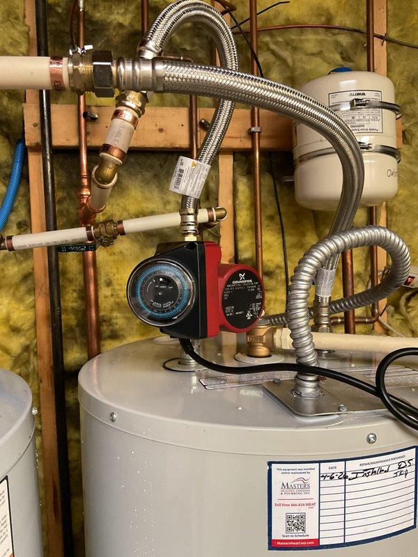 Installed Grundfos recirculation pump with comfort valve at water heater to address extended hot water delivery time to master bathroom lavatories. Mounted pump assembly on top of water heater tank with appropriate copper and flexible connector piping, installed digital control unit, and positioned comfort valve under master bathroom sink cabinet. System tested and operational, significantly reducing wait time for hot water delivery to fixtures.