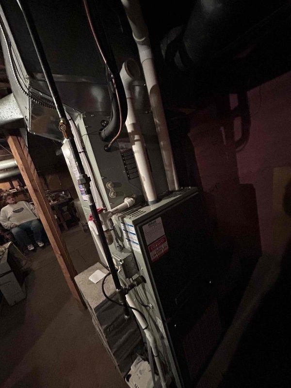 Conducted equipment evaluation and provided replacement estimate for 11-year-old gas furnace system in basement location. Previous service provider had diagnosed failed heat exchanger and disabled unit for safety. Assessed existing HVAC installation including furnace, ductwork, venting system with PVC exhaust pipes, refrigerant lines, and electrical connections. Documented current equipment condition and configuration through detailed photography of mechanical room setup. Presented replacement options and specifications for new gas furnace system to restore heating capability to residence.