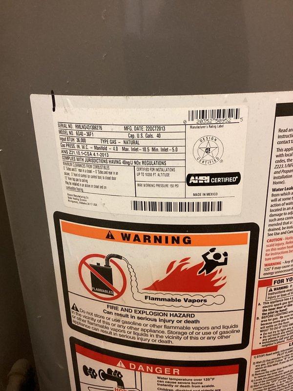 Responded to no hot water complaint on residential natural gas tanked water heater. Inspected Richmond brand 40-gallon atmospheric vent water heater (model GCWU-40, manufactured October 2013) located in utility room behind dryer. Performed diagnostic assessment of unit, verified gas supply, checked pilot light operation, and inspected burner assembly and thermocouple. Evaluated flue venting system and temperature pressure relief valve for proper operation. Documented equipment condition and safety label compliance with photographs for service records.