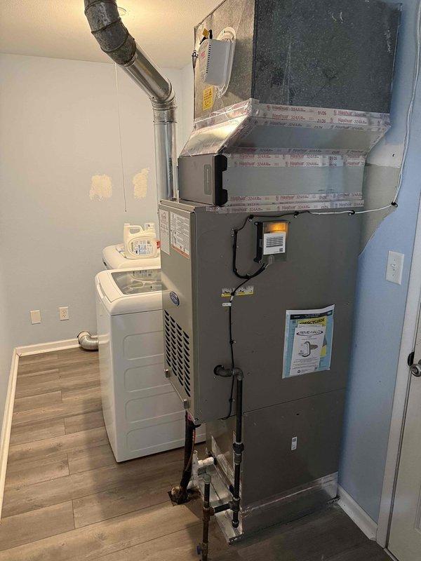 Completed full HVAC system installation including Carrier 26SPA624W003 Performance Series single-stage air conditioner (2.5 ton), Carrier CVAVA3017XMA evaporator coil, and Carrier 58TP0B070V17-16 Performance Series two-stage 70,000 BTU non-condensing gas furnace in indoor utility room. Removed and recycled existing equipment, then installed new air handler unit on elevated stand with proper clearances. Reconnected system to existing refrigerant line set, performed thorough flush and pressure testing to verify system integrity. Installed new Honeywell T6 programmable thermostat and verified proper communication with HVAC equipment. Completed all electrical connections, ran and secured refrigerant lines along air handler cabinet, and connected flexible ductwork to existing duct system with proper sealing. Obtained necessary permits and ensured all installation work met local code requirements. Performed system startup procedures, verified proper airflow through supply and return ducts, a