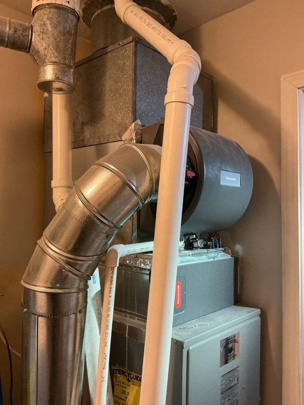 Conducted on-site assessment of existing residential HVAC system for air conditioning unit replacement estimate. Evaluated current equipment configuration including furnace, ductwork, humidifier, and associated components within utility closet installation. Documented system layout, existing infrastructure, and mechanical room dimensions through photographic documentation to determine replacement specifications and compatibility requirements for new AC unit installation.