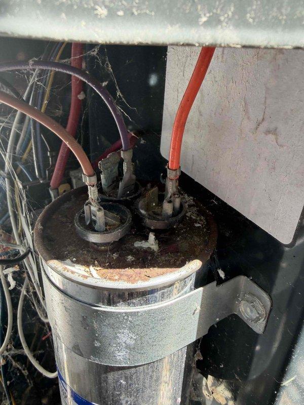 Completed standard AC tune-up on residential outdoor condensing unit. Performed visual inspection of electrical components including dual-run capacitor and contactor assembly, verified all wire connections secure at terminals, and assessed overall system condition. Unit showing normal signs of age with dust accumulation on internal components and minor surface corrosion on capacitor housing, but all components functioning within acceptable parameters at time of service.