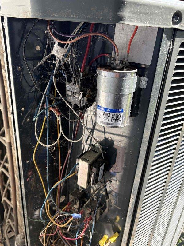 Completed standard AC tune-up on residential outdoor condensing unit. Performed visual inspection of electrical components including dual-run capacitor and contactor assembly, verified all wire connections secure at terminals, and assessed overall system condition. Unit showing normal signs of age with dust accumulation on internal components and minor surface corrosion on capacitor housing, but all components functioning within acceptable parameters at time of service.