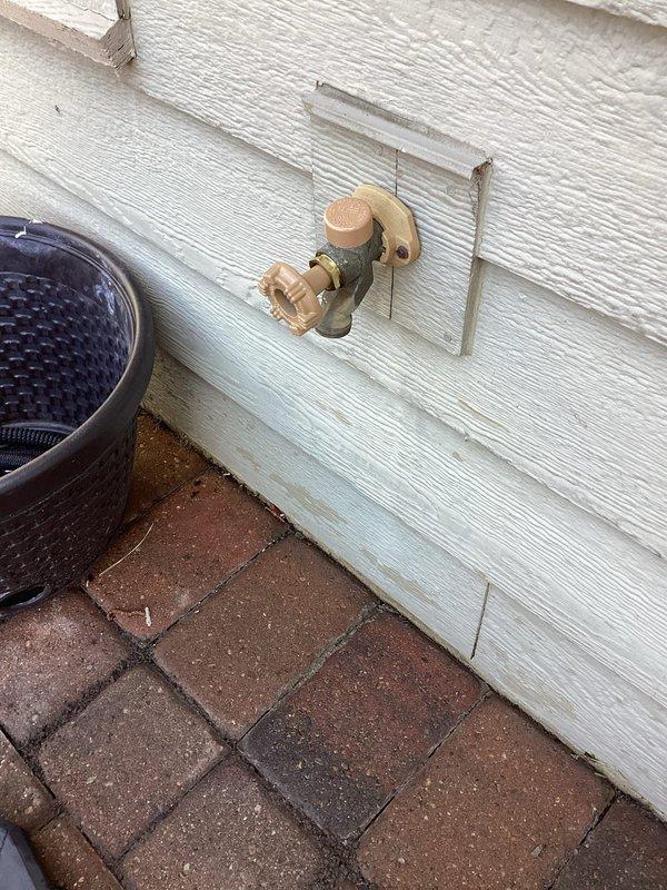Responded to service call for two outdoor spigots experiencing leaks. Inspected first hose bib mounted on vinyl siding above brick paver patio, which exhibited leaking from the top valve assembly. Examined second outdoor spigot with brass and chrome valve components, identified leak originating from bottom connection point. Documented both fixtures with photographs showing mounting configuration, valve conditions, and leak sources for repair assessment and parts ordering.
