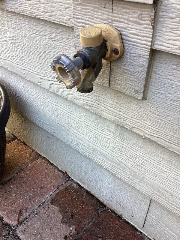 Responded to service call for two outdoor spigots experiencing leaks. Inspected first hose bib mounted on vinyl siding above brick paver patio, which exhibited leaking from the top valve assembly. Examined second outdoor spigot with brass and chrome valve components, identified leak originating from bottom connection point. Documented both fixtures with photographs showing mounting configuration, valve conditions, and leak sources for repair assessment and parts ordering.