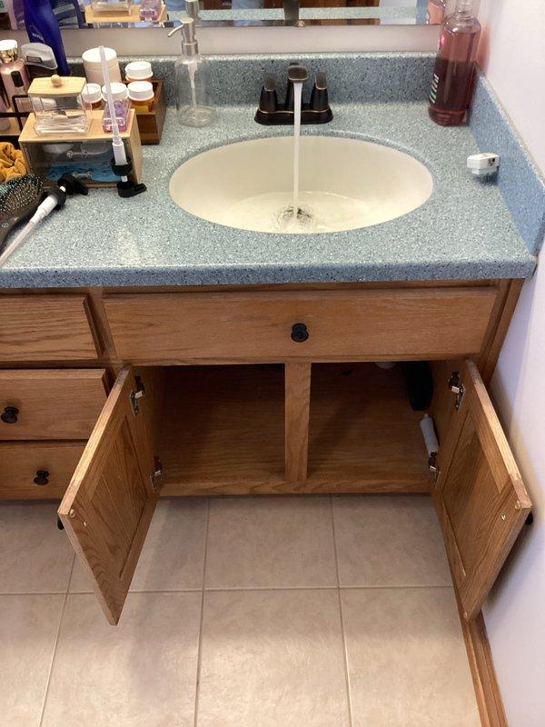 Responded to service request for bathroom plumbing fixture replacement. Successfully replaced two bathroom faucets with chrome fixtures featuring black handles, ensuring proper installation and water flow. Replaced existing drain pipes and P-trap assembly with new white PVC components, creating proper drainage configuration. Installed new braided stainless steel supply lines connected to angle stop shutoff valves for both hot and cold water feeds. Tested all connections for leaks, verified proper water pressure and drainage flow, and confirmed all plumbing components functioning correctly upon completion.