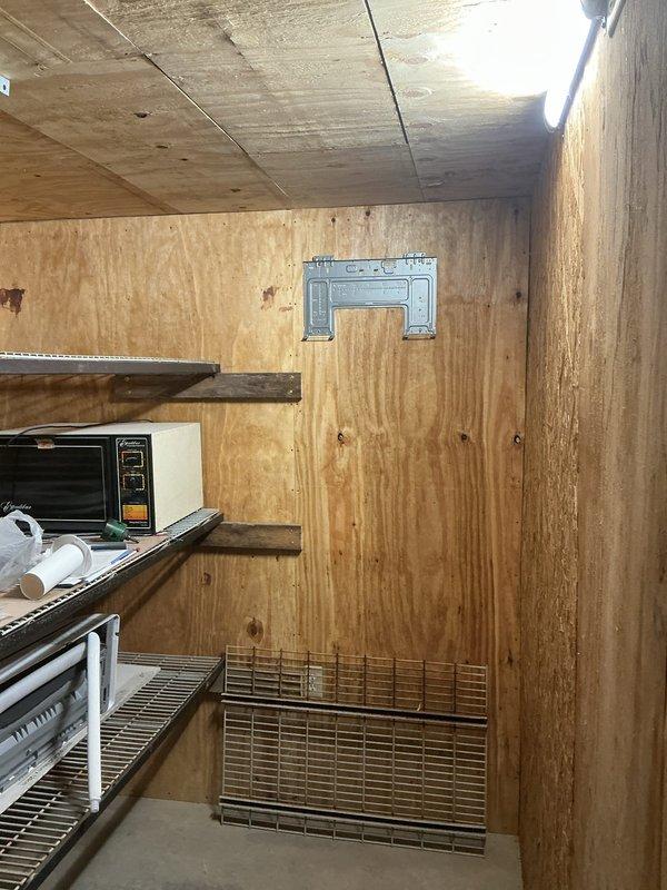 Provided estimate for completing installation of customer-supplied Mr Cool mini split system in barn structure consisting of one outdoor and one indoor unit. System requires refrigerant line set installation, electrical power connection to indoor unit, and professional startup service. Indoor unit mounted on interior plywood wall accessible via step ladder, outdoor unit installed on exterior red metal siding with electrical disconnect box in place.