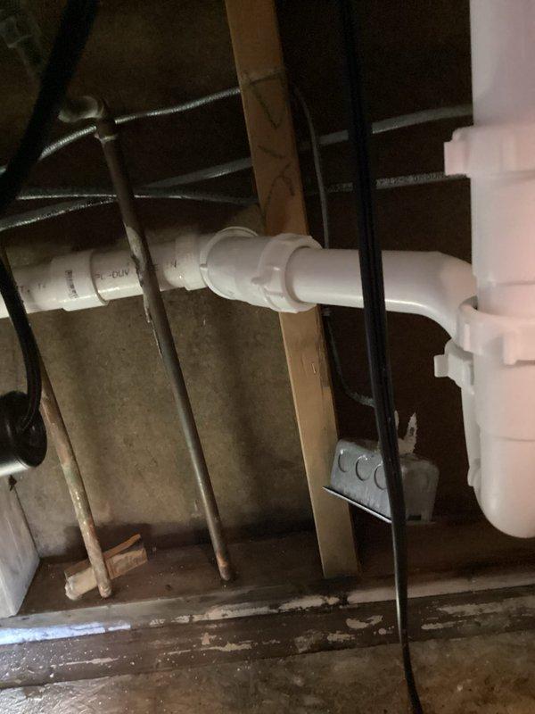 Returned to property to access previously identified leak locations in bathroom and kitchen areas. Opened wall and ceiling cavities to expose plumbing systems for repair work. Inspected and repaired leaking connections on PVC drain assemblies beneath fixtures, including P-trap installations and horizontal drain lines. Accessed crawl space and attic areas to address leaking pipes running through structural framework, repairing compromised joints and fittings on both horizontal and vertical PVC drainage systems. Secured all repaired plumbing connections and verified proper drainage flow with no active leaks present upon completion.