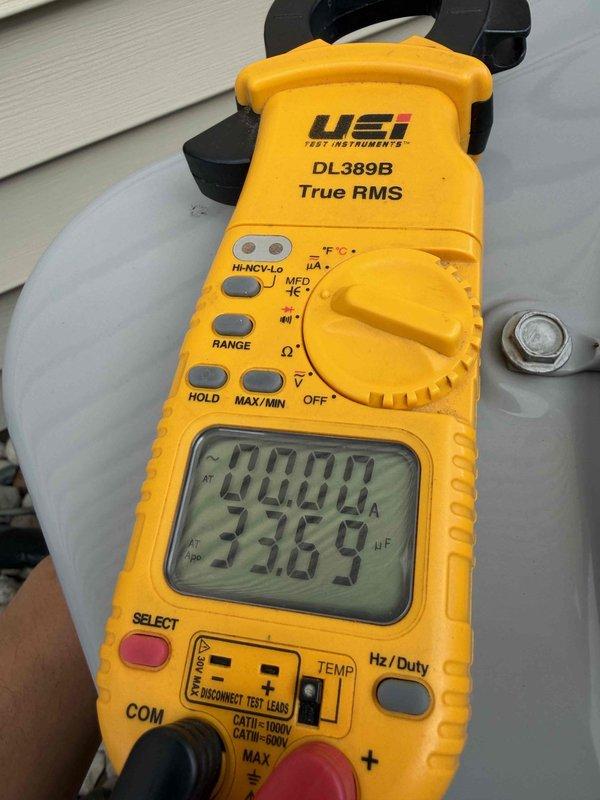 Completed comprehensive air conditioning tune-up service on outdoor condensing unit. Performed electrical diagnostics using clamp meter, measuring capacitance at 33.69 μF to verify proper compressor and fan motor operation. Inspected condenser coil through fan grille, confirmed unit cleanliness, verified proper airflow, and ensured all components were functioning within normal operating parameters.