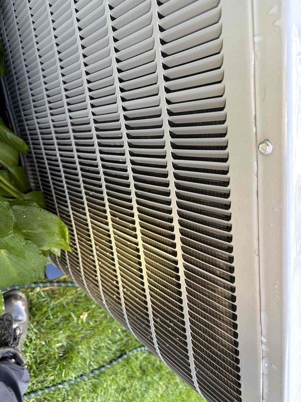 Completed first preventative maintenance visit on residential air conditioning system under maintenance agreement expiring May 2027. Inspected outdoor condensing unit, noting visible dirt accumulation and environmental staining on lower portion of unit grille requiring attention during future service intervals. Documented equipment condition with photos showing exterior ventilation components and grille assembly. Customer notified technician is en route as requested and has separately scheduled heating system maintenance visit.