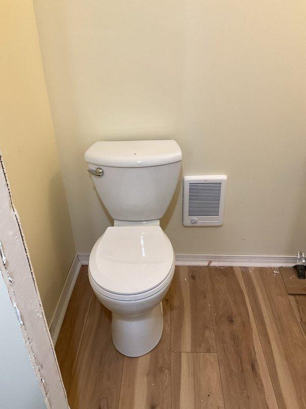 Completed final plumbing installation for new bathroom fixtures including pedestal sink with two-handle faucet assembly and toilet installation. Applied caulking around sink base and wall connections to ensure proper water-tight seal. Verified all water supply connections, drain assemblies, and fixture mounting for code compliance and proper operation.