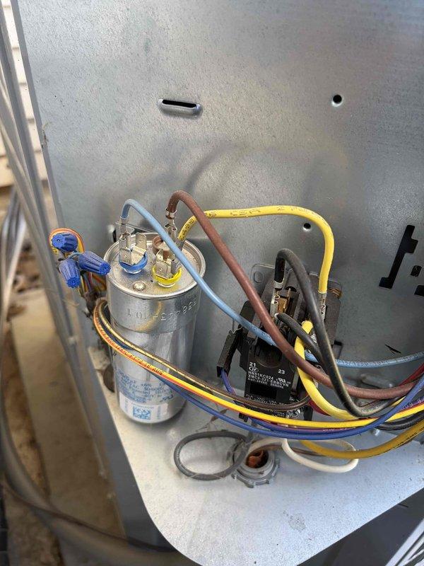 Performed routine maintenance inspection on residential cooling system. Checked and documented system temperatures, recording 53.8°F reading at filter drier/accumulator component using digital diagnostic instrument. Inspected electrical components including capacitor, contactor relay, and associated wiring connections within unit cabinet, verifying all connections were secure and components showed normal operating condition.