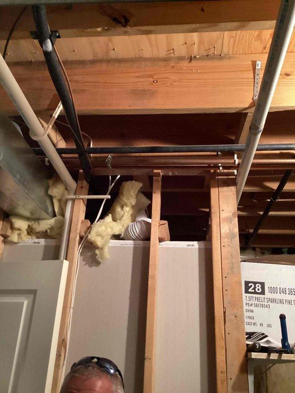 # HVAC Service Call - No Cooling

Responded to service call for 26-year-old Goodman air conditioning system with complete loss of cooling and no system operation. Upon arrival, performed comprehensive diagnostic evaluation of entire HVAC system including furnace, air handler, and associated components.

Conducted visual inspection of equipment in basement mechanical room, noting age and condition of existing Goodman furnace unit and connected ductwork. Examined electrical connections, control wiring, and power supply to determine cause of system failure. Inspected refrigerant lines, ductwork connections, and insulation in ceiling area for signs of damage or deterioration.

Evaluated system specifications using manufacturer labels and documentation affixed to equipment. Assessed water heater proximity and clearances to HVAC components. Photographed equipment configuration and installation details for service documentation.

Given the advanced age of the 26-year-old system, discussed sys