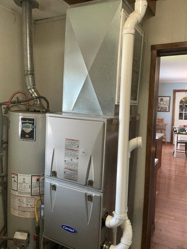 Responded to no-cooling complaint and performed diagnostic evaluation of residential HVAC system. Found outdoor unit condenser coil severely deteriorated and non-functional. Confirmed thermostat calling for cooling mode but system not producing conditioned air, though outdoor fan motor operational. Documented existing Carrier furnace and current ecobee smart thermostat installation. Provided estimate for complete air conditioning system replacement due to failed evaporator coil and associated equipment condition.
