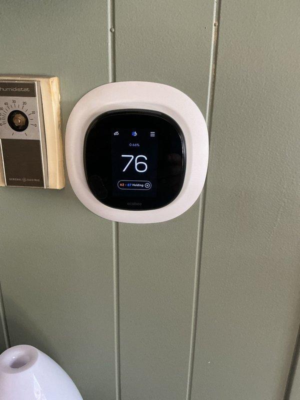 Responded to no-cooling complaint and performed diagnostic evaluation of residential HVAC system. Found outdoor unit condenser coil severely deteriorated and non-functional. Confirmed thermostat calling for cooling mode but system not producing conditioned air, though outdoor fan motor operational. Documented existing Carrier furnace and current ecobee smart thermostat installation. Provided estimate for complete air conditioning system replacement due to failed evaporator coil and associated equipment condition.