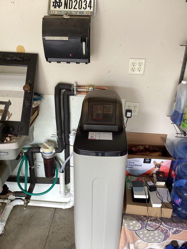 Successfully installed water softener system in utility area per customer specifications. Connected unit to existing plumbing infrastructure using copper supply lines and integrated with pre-existing filtration system. All connections secured and tested for proper operation.
