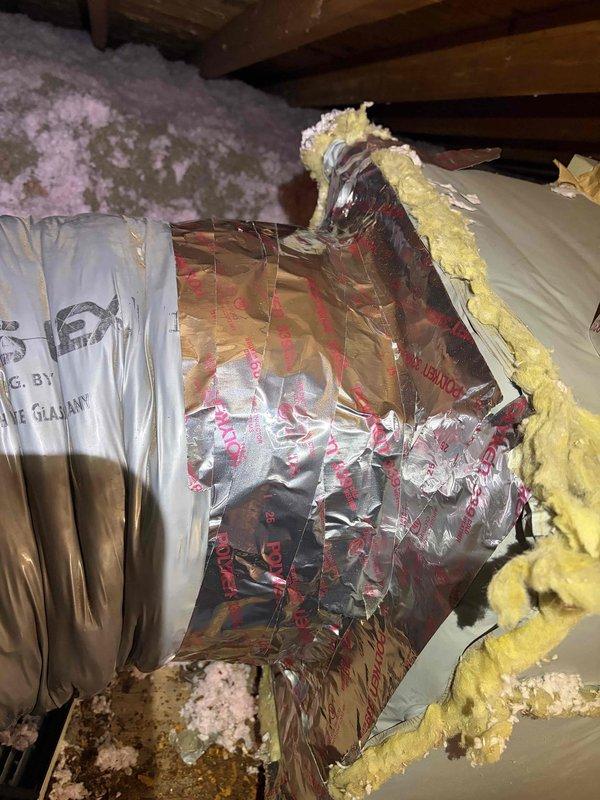 Responded to no cooling complaint where system was unable to maintain setpoint of 67°F, with indoor temperature reaching only 73°F. Upon inspection, discovered severely deteriorated ductwork insulation in attic space with multiple tears, punctures, and compromised vapor barrier allowing significant air leakage and thermal loss. Observed organic debris infiltration indicating unsealed duct connections. Documented extensive damage to flexible ductwork wrap and degraded fiberglass insulation throughout accessible attic areas. Recommended complete duct sealing and insulation replacement to restore system efficiency and proper cooling capacity. Noted air filter accessibility issue requiring ladder access, with uncertain maintenance history contributing to reduced airflow and system performance.