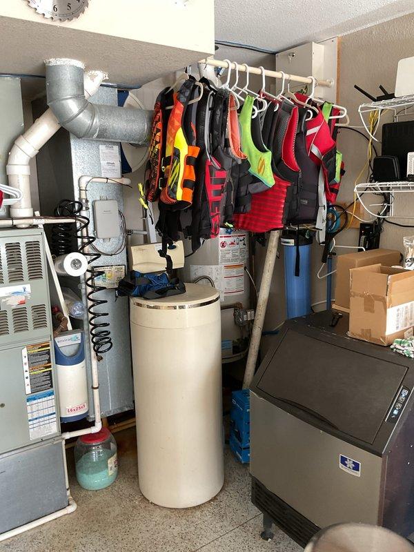 Conducted on-site evaluation of existing gas-fired storage tank water heater located in garage utility area for potential replacement with tankless electric water heater system. Assessed current installation including gas supply connections, venting configuration, electrical infrastructure, available clearances, and plumbing connections. Documented existing water heater specifications, sediment filtration system, copper supply piping with flexible connectors, and available space constraints within mechanical room. Provided comprehensive estimate for tankless electric water heater conversion including electrical service upgrade requirements, reconfiguration of water supply lines, and removal of existing gas appliance.