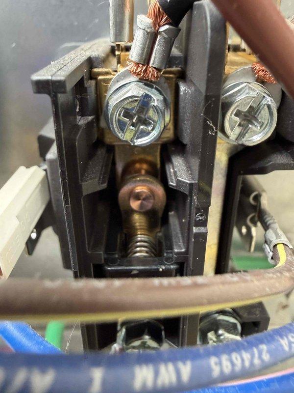 Performed routine maintenance inspection on residential cooling system. Verified electrical connections at contactor assembly, confirming proper wire termination and secure mounting of all conductors. Measured and recorded system amperage draw using clamp meter, with readings indicating normal operating parameters at 40.00A and 39.73A, confirming compressor is functioning within manufacturer specifications.