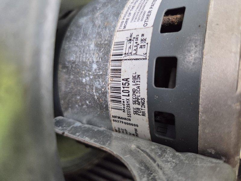 Responded to no cooling complaint on park model HVAC unit where system was powering on but no airflow was detected through vents. Upon arrival, performed diagnostic inspection of blower assembly and motor components. Inspected blower motor assembly, housing, and mounting bracket for proper operation and mechanical integrity. Examined motor label specifications and verified model number L013A. Assessed blower wheel condition and checked for obstructions or mechanical binding. Evaluated motor wiring connections and electrical components for proper functionality. Documented condition of blower assembly showing dust accumulation and normal wear patterns on housing and motor surfaces. Verified mounting hardware and support brackets were secure. Photographed motor assembly and blower housing for service records showing component identification labels and overall unit condition.