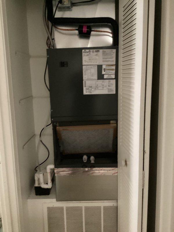 # HVAC System Installation

Successfully installed customer-supplied air handler and outdoor condensing unit at residential property. The new Carrier air conditioning system was positioned on gravel pad against exterior stone wall, with proper clearances maintained for service access and airflow. Indoor air handler with evaporator coil was installed in end closet location, featuring vertical configuration with refrigerant lines properly secured and insulated. All electrical connections, condensate drainage, and PVC piping were completed to manufacturer specifications. System startup performed with refrigerant lines pressure tested and equipment operational.