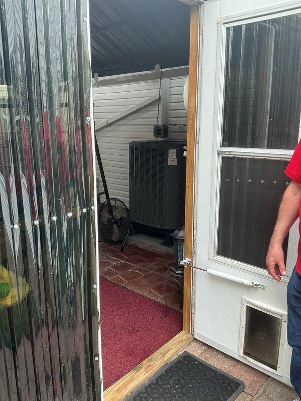 Conducted site assessment for heat pump relocation estimate. Documented existing 10-year-old heat pump unit currently installed in enclosed porch area and photographed proposed relocation site approximately 100 feet from current location to accommodate potential home addition. Evaluated attic access and structural considerations for equipment repositioning and potential system resizing requirements for expanded conditioned space.