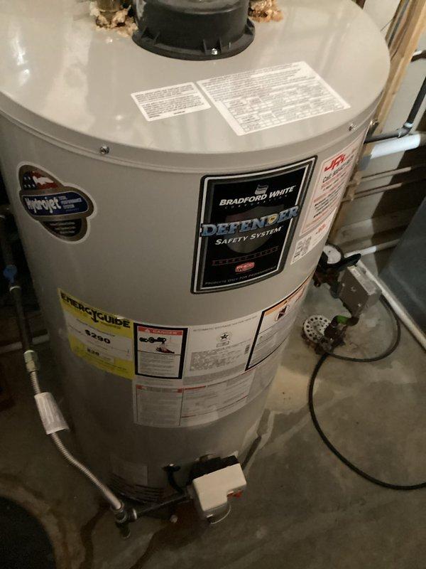 Responded to service call for leaking gas-fired 50-gallon Bradford White tanked water heater located in basement. Upon inspection, confirmed active leak from existing unit positioned on elevated stand. Assessed system configuration including existing copper supply lines, flexible connectors, gas supply, and venting arrangement. Documented equipment condition and surrounding plumbing infrastructure. Provided replacement quote for new water heater installation. Pulled necessary permit for replacement work. Unit requires complete removal and replacement due to tank failure.
